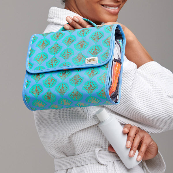 hanging wash bag in blue  shell print held by woman